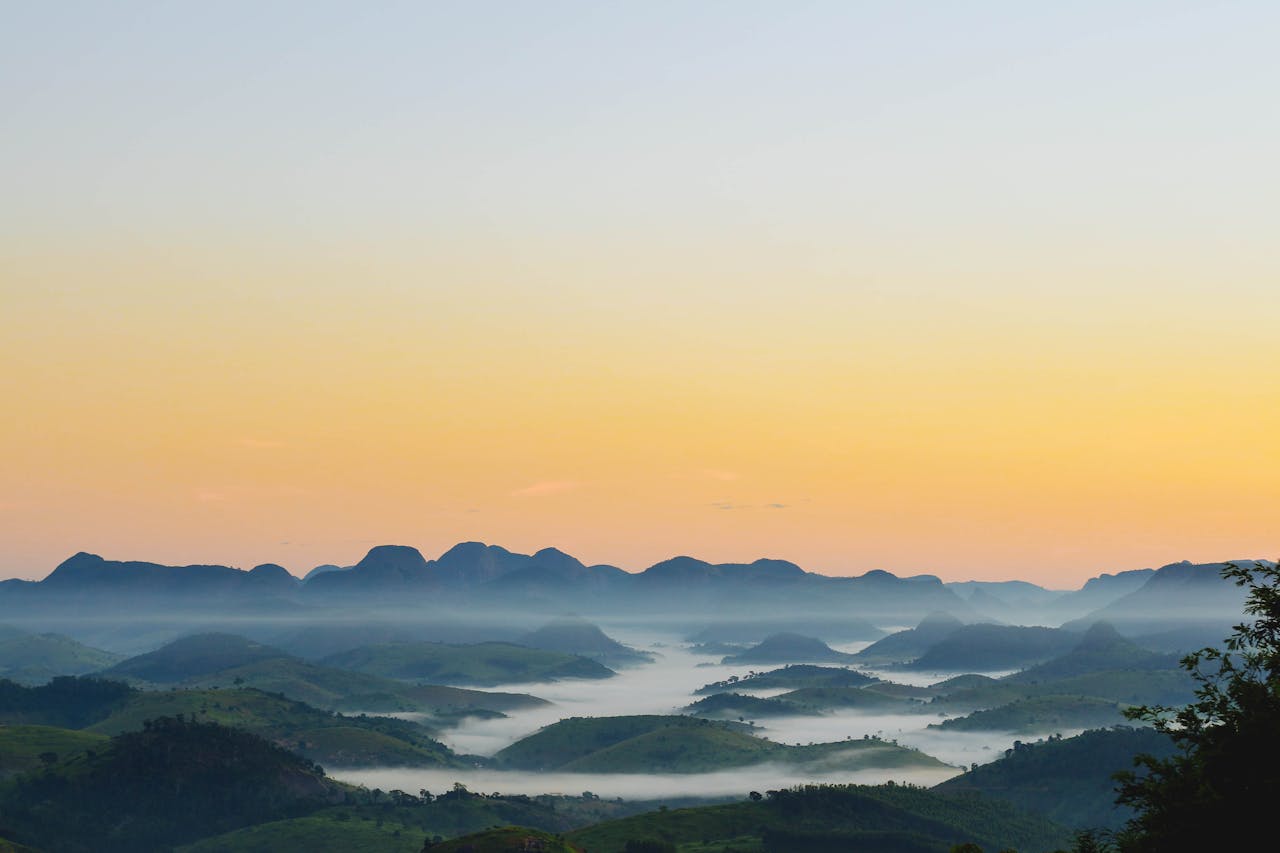 about-03 Breathtaking view of sunrise over misty mountains in Barra de São Francisco, Brazil.